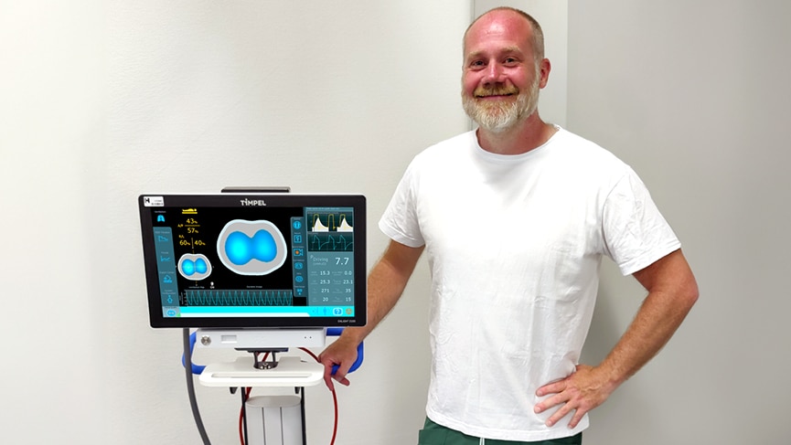 Doctor standing next to a ventilation monitor.